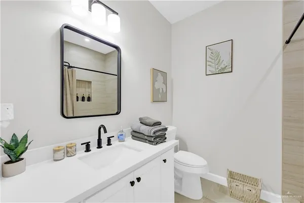 a bathroom with a toilet a sink and mirror