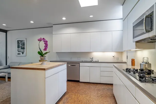 a kitchen with granite countertop a table chairs stove a sink and dishwasher