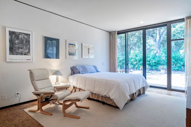 a bedroom with a large bed and a painting on the wall