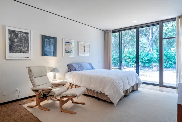 a bedroom with a large bed and a painting on the wall