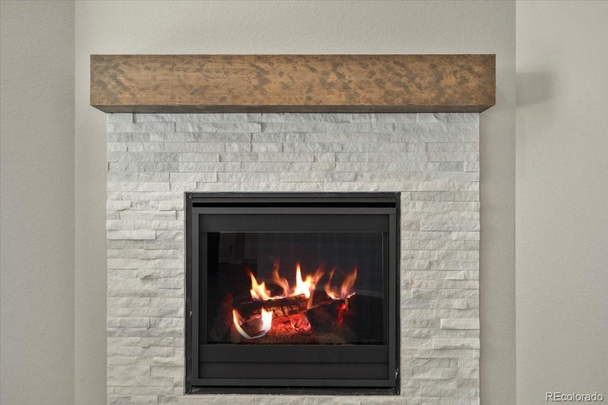8178 Mount Harvard Road Littleton, CO 80125 - Photo 14 of 39 a fireplace with a clock on wall