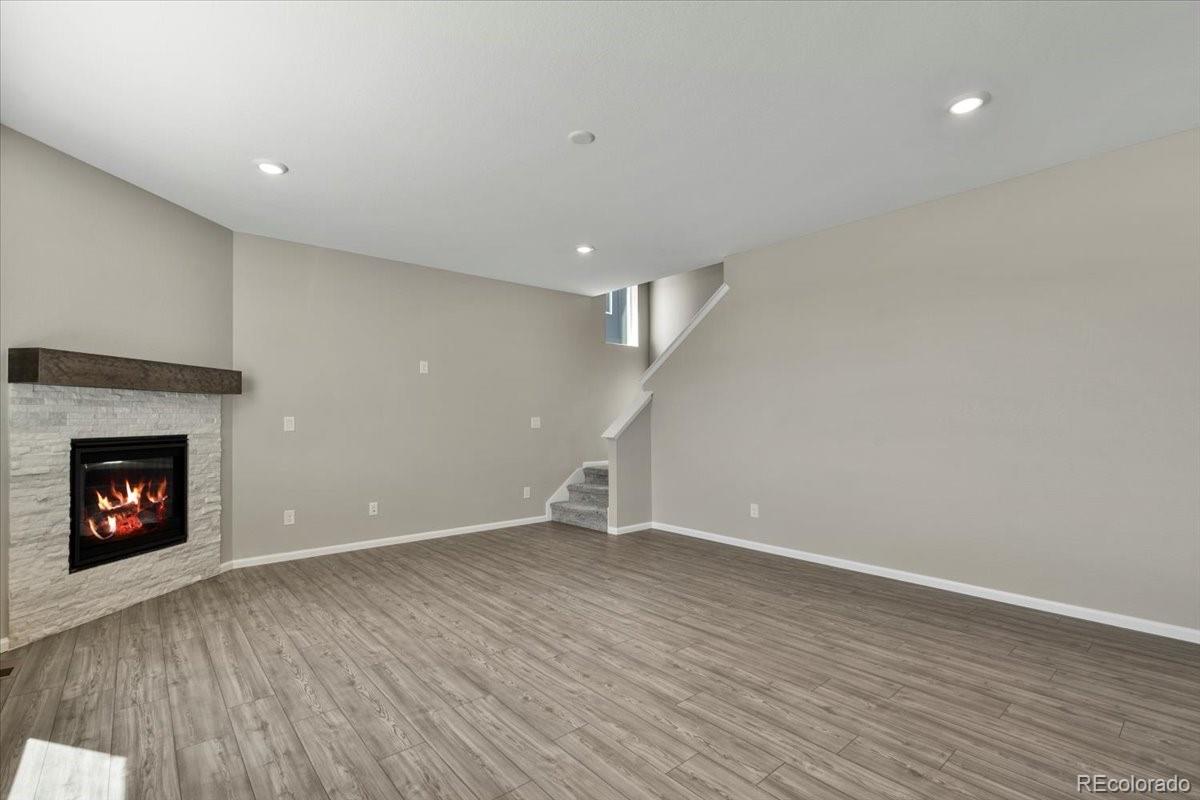 8178 Mount Harvard Road Littleton, CO 80125 - Photo 15 of 39 a view of an empty room with wooden floor fireplace and a window