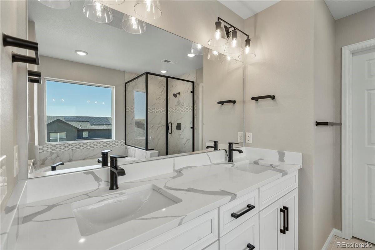 8178 Mount Harvard Road Littleton, CO 80125 - Photo 25 of 39 a bathroom with a sink double vanity and a mirror
