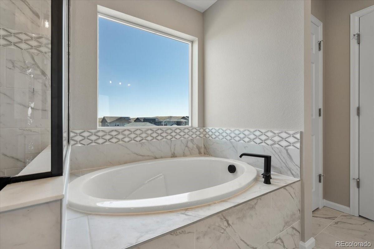 8178 Mount Harvard Road Littleton, CO 80125 - Photo 26 of 39 a white bath tub sitting in a bathroom
