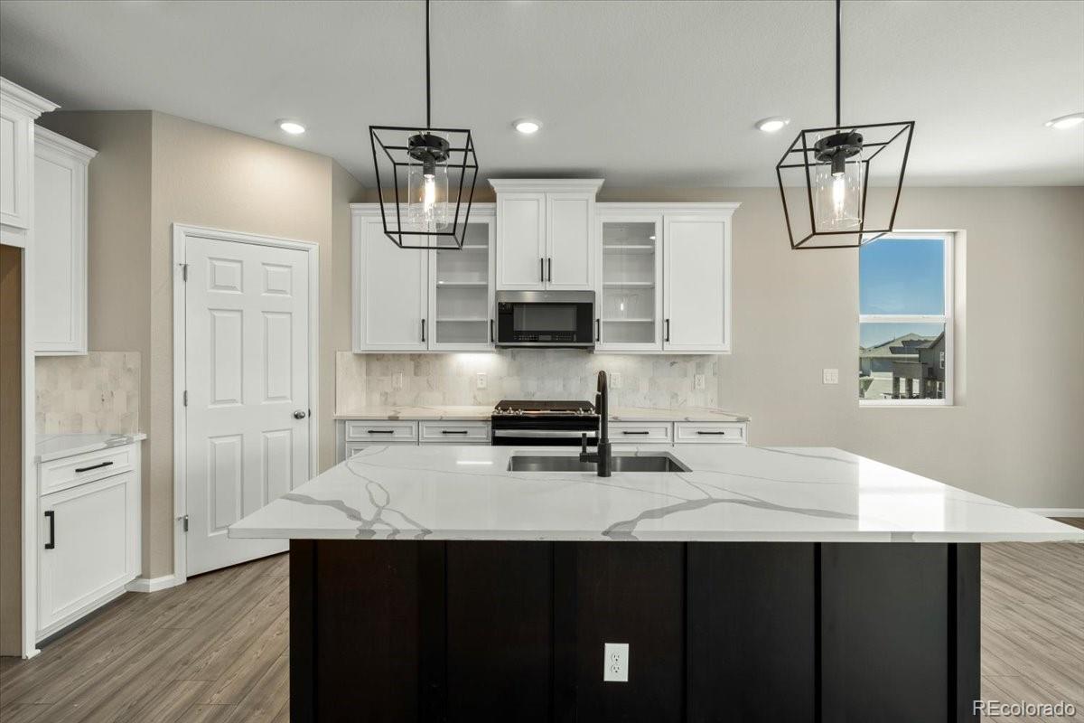 8178 Mount Harvard Road Littleton, CO 80125 - Photo 9 of 39 a kitchen with a sink stainless steel appliances and cabinets