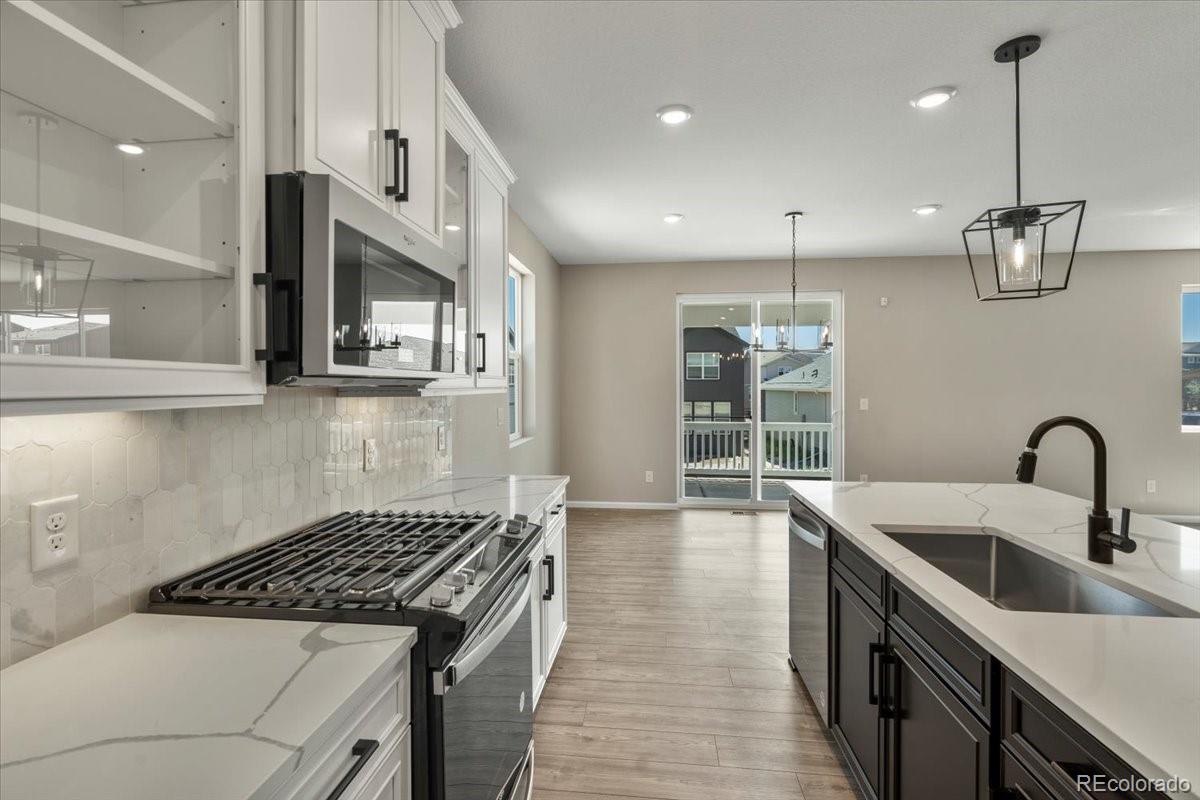 8178 Mount Harvard Road Littleton, CO 80125 - Photo 10 of 39 a kitchen with stainless steel appliances granite countertop a sink a stove and a wooden floors