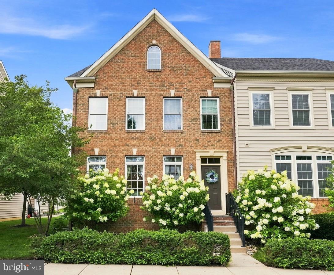 Charming brick facade with lush blooms.