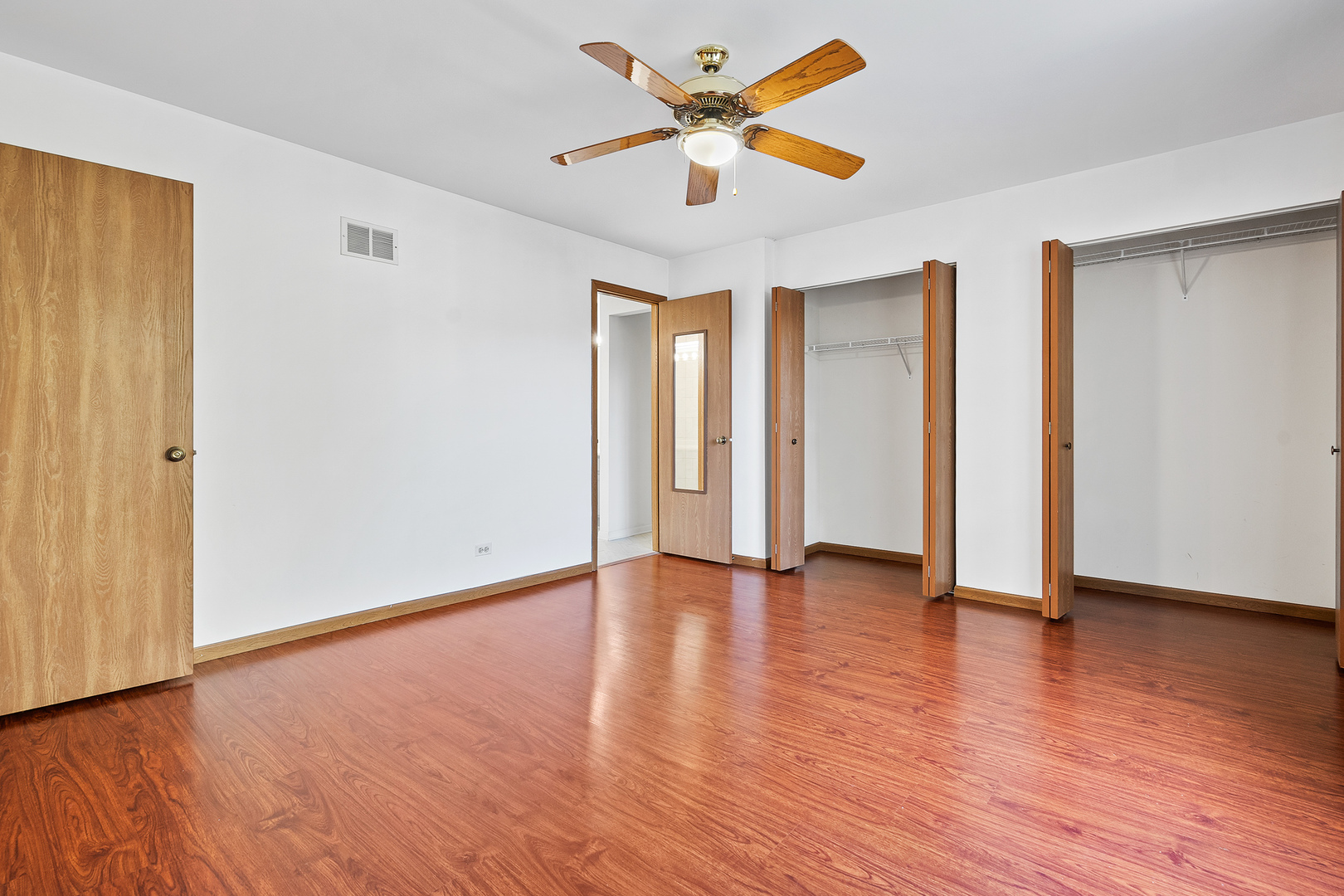 1404 West Sapphire Drive Hoffman Estates, IL 60192 - Photo 18 of 29 an empty room with wooden floor and ceiling fan