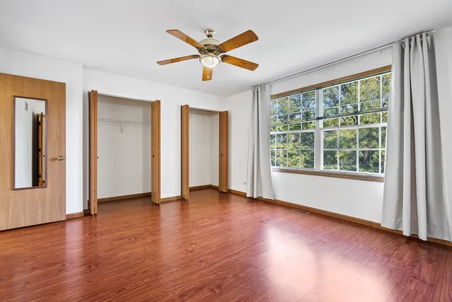 a view of a livingroom with wooden floor and a ceiling fan