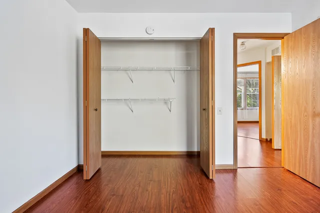 an empty room with wooden floor and entrance