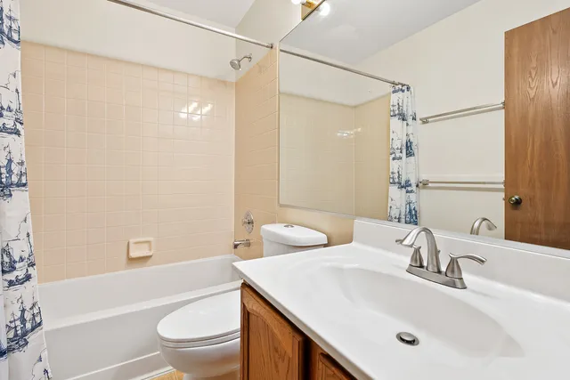 a bathroom with a sink toilet vanity and shower
