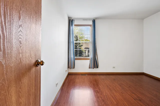 a view of a room with wooden floor and a window