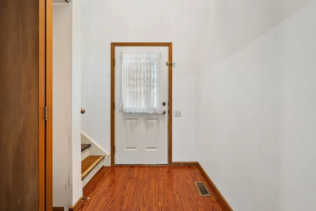 a view of a hallway with wooden floor and entryway