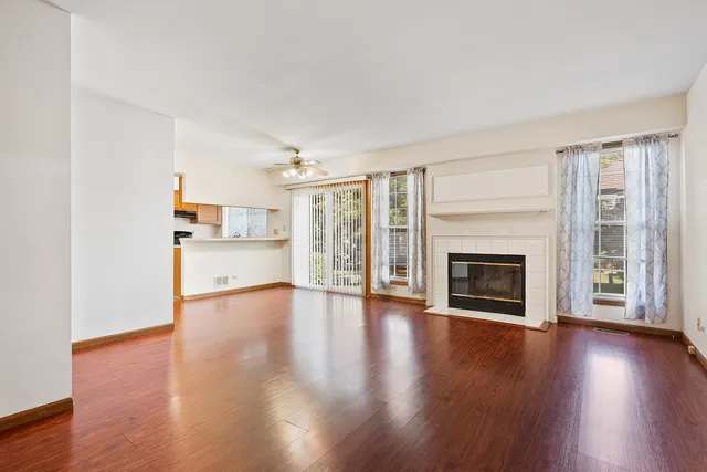 a view of a livingroom with wooden floor and a fireplace