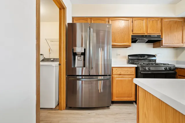 a kitchen with a refrigerator a stove top oven a sink and cabinets
