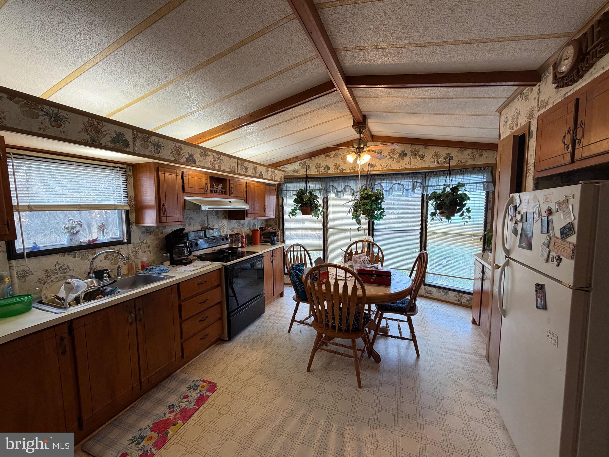 232 Yankee Road, Unit 156 Quakertown, PA 18951 - Photo 6 of 12 a kitchen with stainless steel appliances kitchen island granite countertop a table chairs sink and cabinets