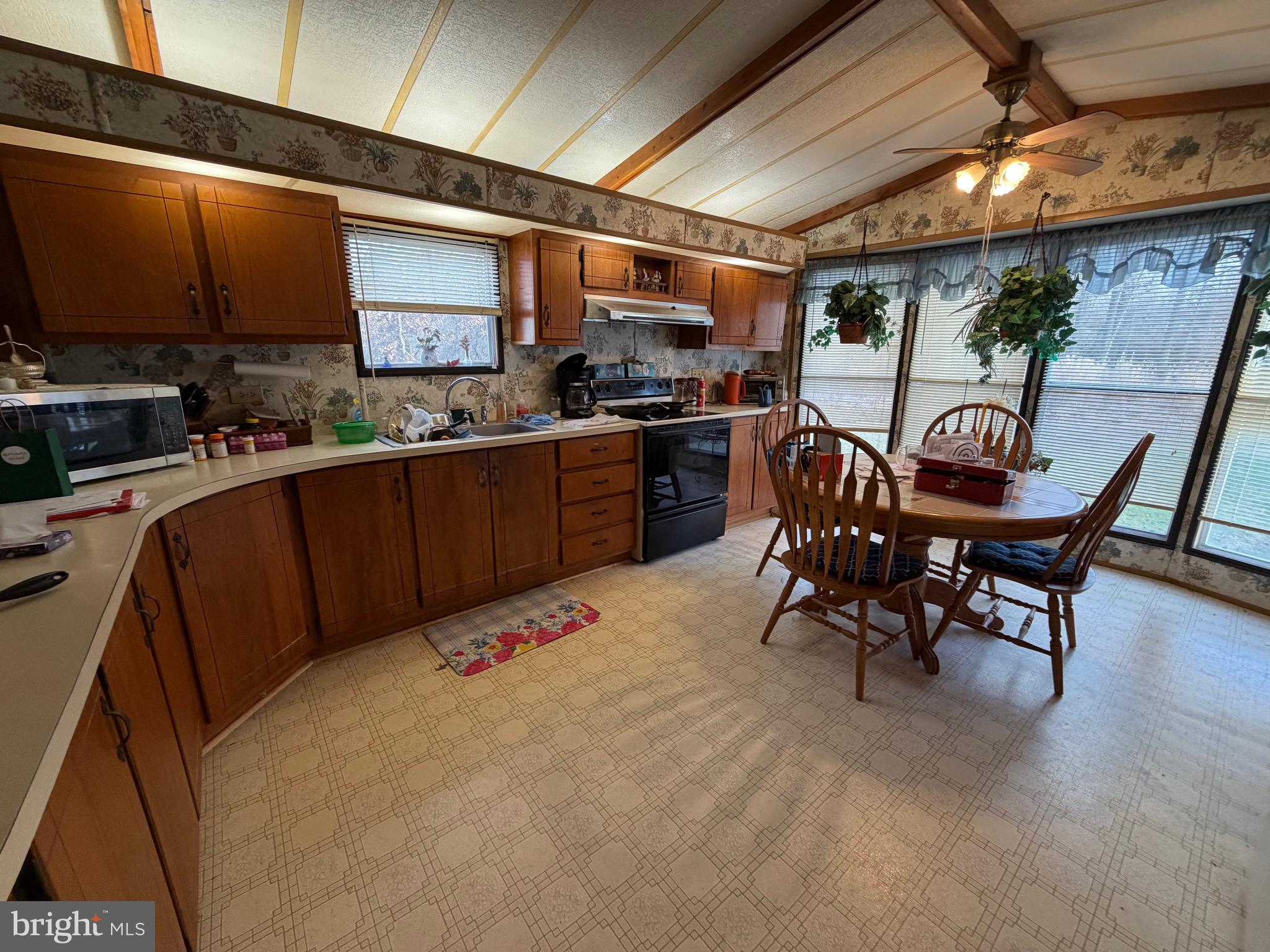 232 Yankee Road, Unit 156 Quakertown, PA 18951 - Photo 8 of 12 a kitchen with stainless steel appliances kitchen island granite countertop a table chairs sink and cabinets
