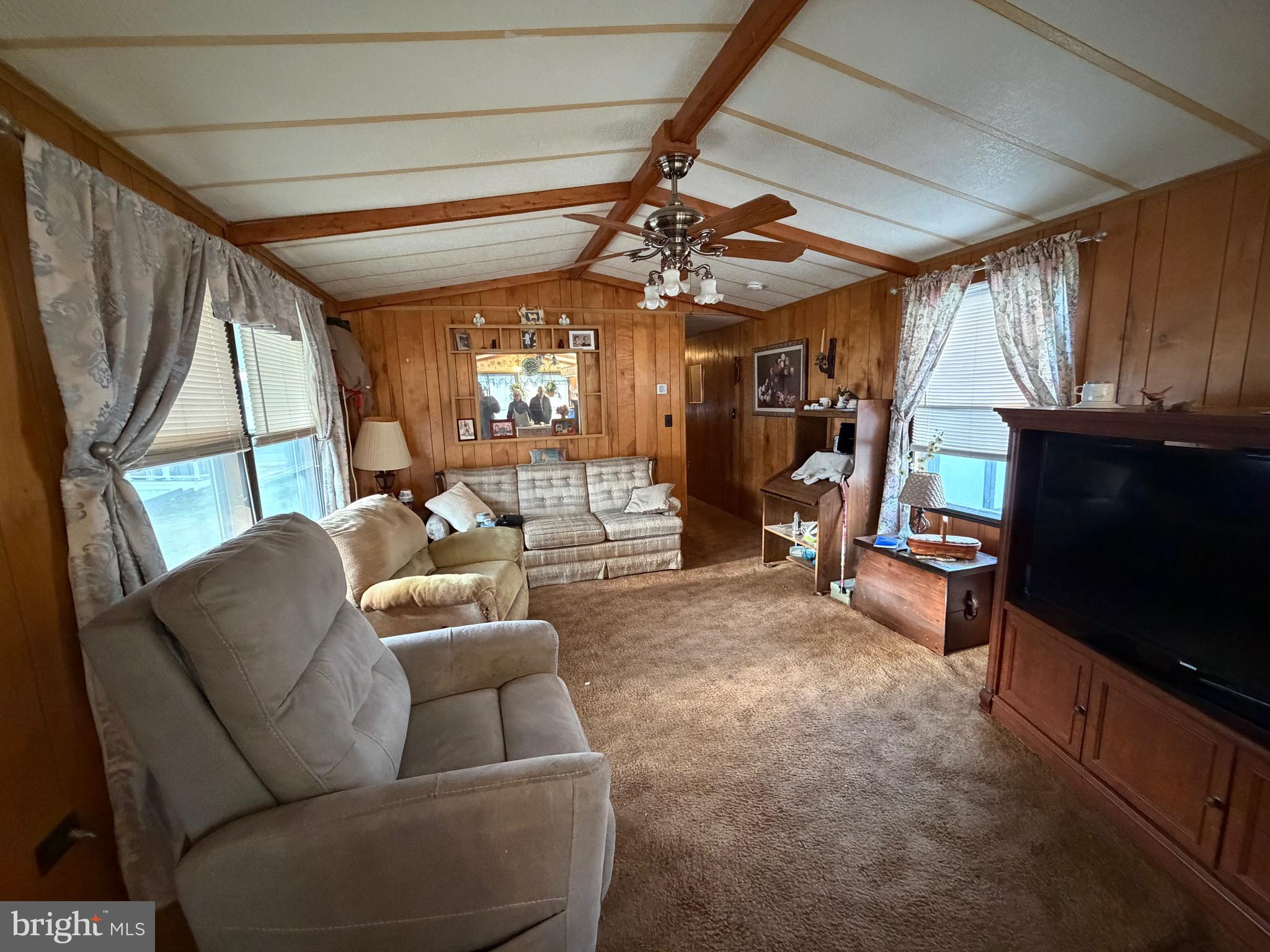 232 Yankee Road, Unit 156 Quakertown, PA 18951 - Photo 9 of 12 a living room with furniture a flat screen tv and a floor to ceiling window