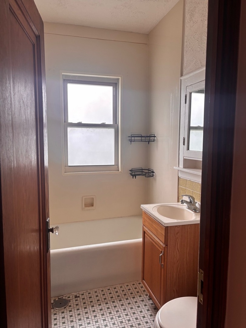 6832 West Medill Avenue, Unit 5 Chicago, IL 60707 - Photo 8 of 16 a bathroom with a sink a toilet and tub