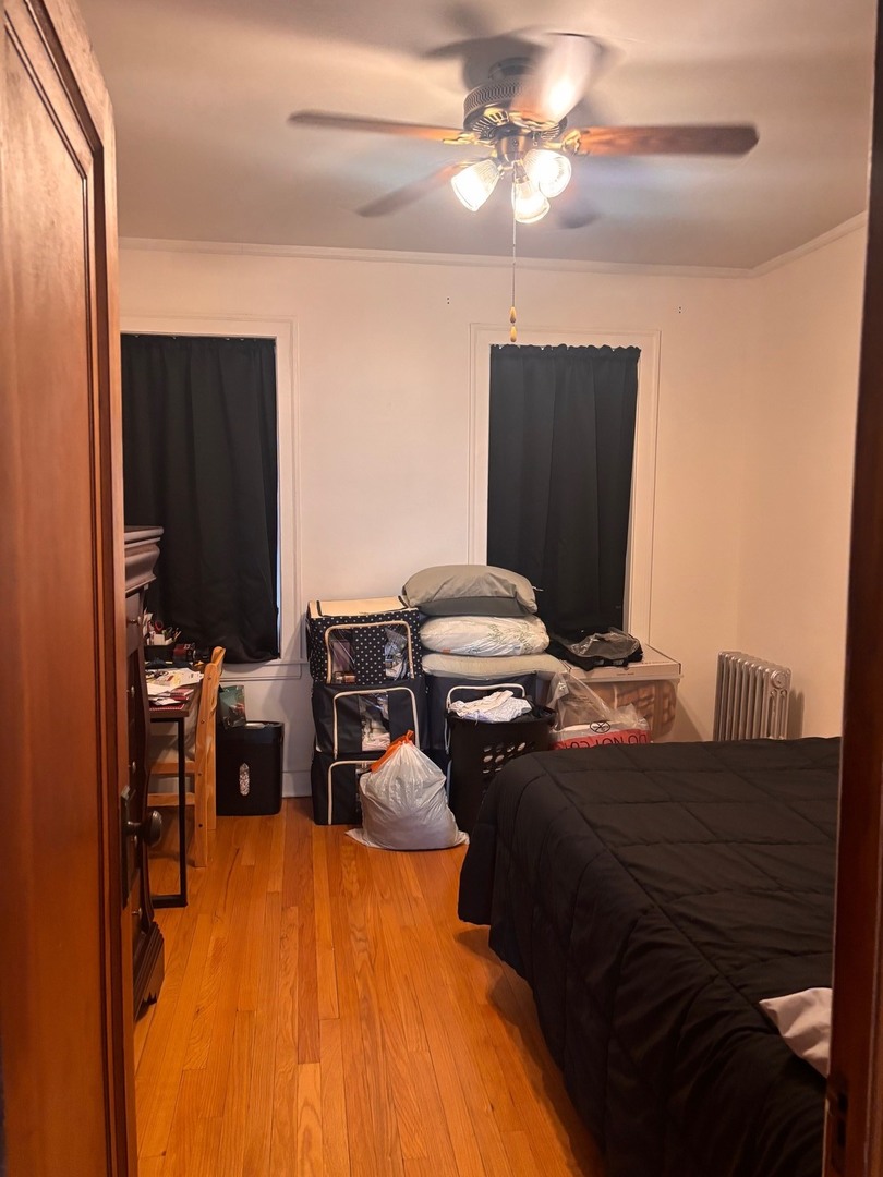 6832 West Medill Avenue, Unit 5 Chicago, IL 60707 - Photo 10 of 16 a bedroom with a bed and a chandelier