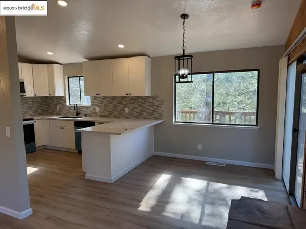 a kitchen with kitchen island granite countertop a stove a sink a center island and wooden floor