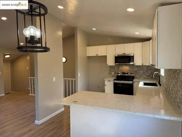 a kitchen with stainless steel appliances a microwave a stove a refrigerator and cabinets