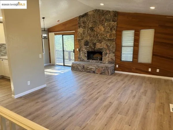 a view of a livingroom with wooden floor and a fireplace