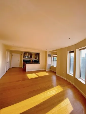 a view of empty room with a fireplace and wooden floor