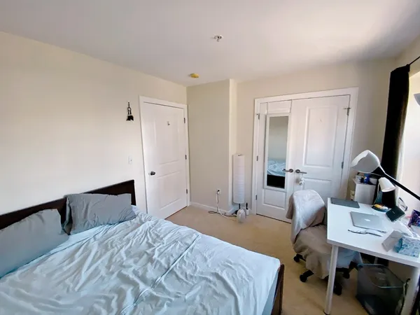 a bedroom with a bed and a desk in it