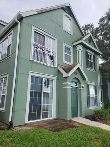 a view of a brick house with a large windows and a yard