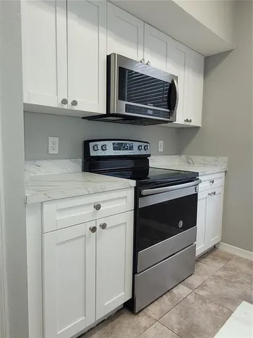 a kitchen with stainless steel appliances granite countertop white cabinets a sink and dishwasher