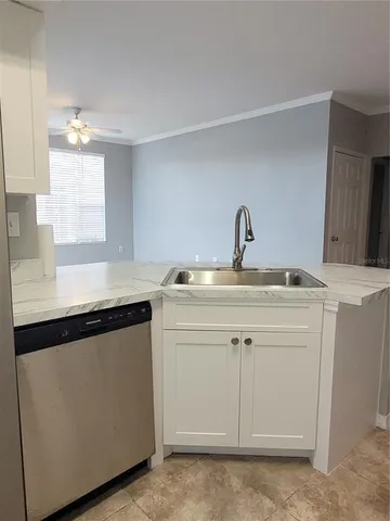 a kitchen with a sink cabinets and a window