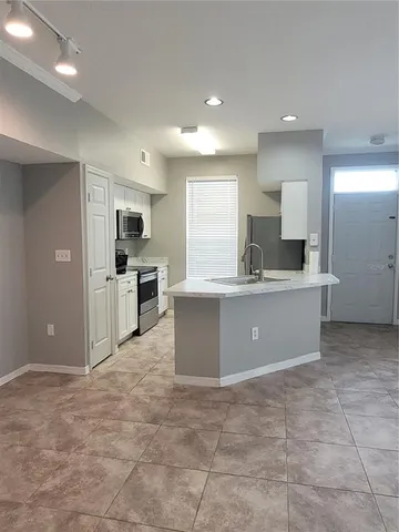a large kitchen with a sink and cabinets