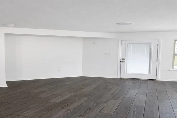 a view of an empty room with wooden floor