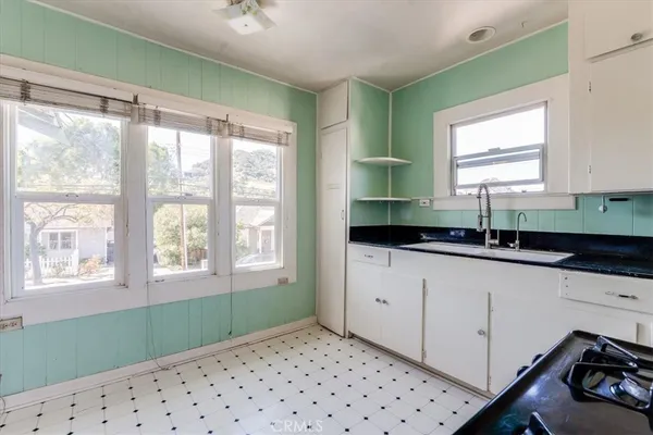 a kitchen with granite countertop a stove a sink and a microwave