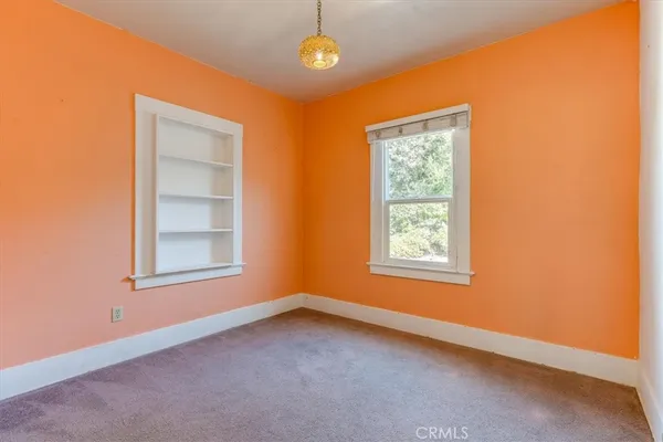 an empty room with a painting on the wall