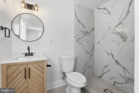 a bathroom with a sink a toilet and a mirror