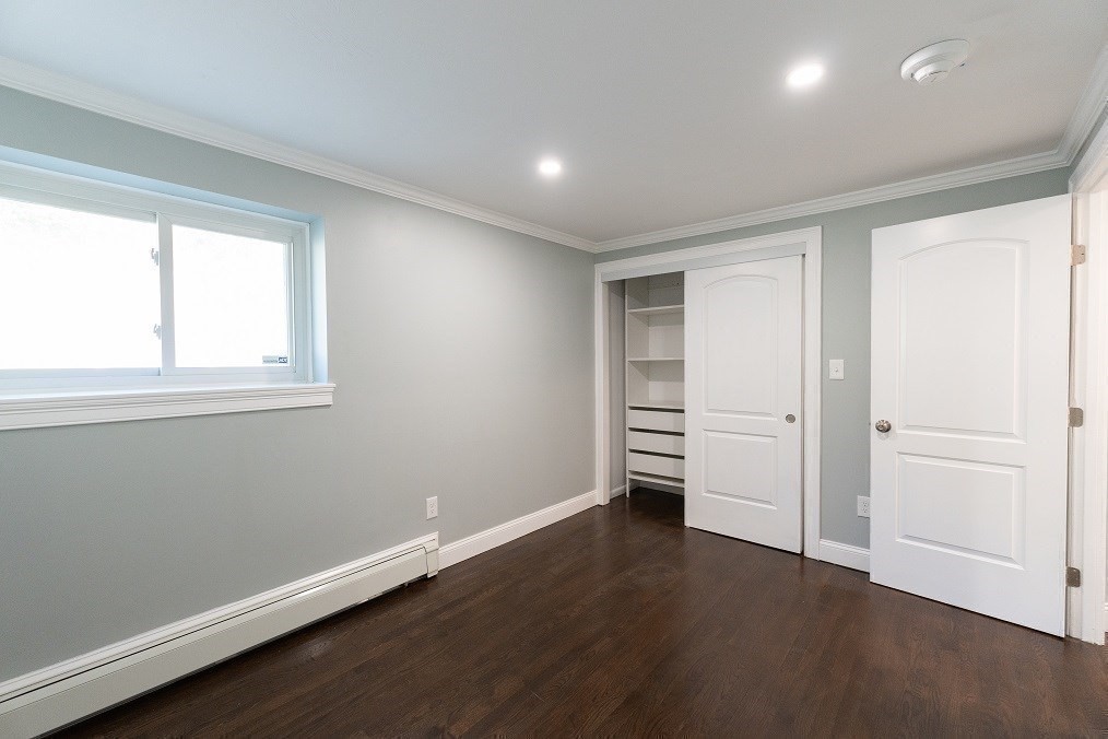 121 Tremont Street, Unit B4 Boston, MA 02135 - Photo 15 of 19 an empty room with wooden floor and window