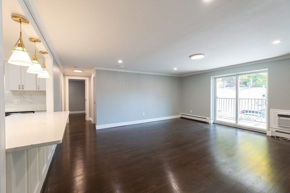 121 Tremont Street, Unit B4 Boston, MA 02135 - Photo 5 of 19 a view of an empty room with wooden floor and a window