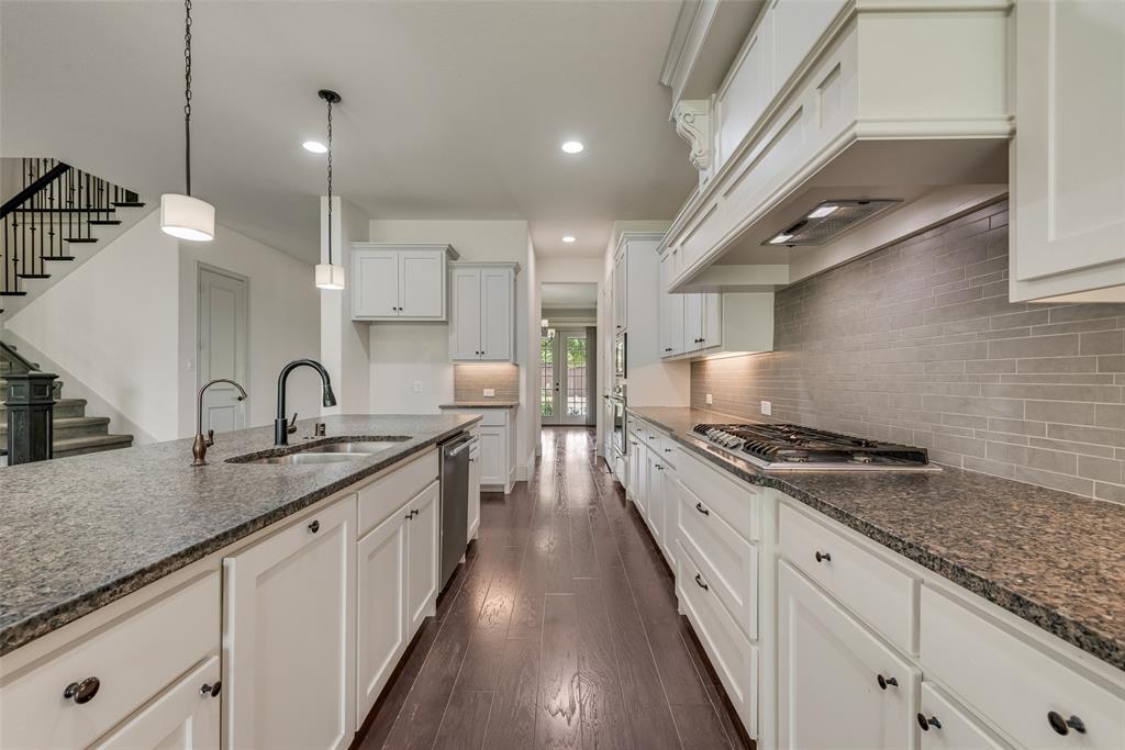 2021 Calisto Way Allen, TX 75013 - Photo 17 of 34 Galley kitchen featuring dark wood-finish flooring, white cabinetry with dark hardware, and speckled countertops