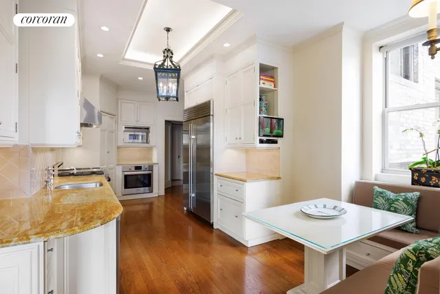 a kitchen with a refrigerator a stove a sink dishwasher with a dining table and chairs