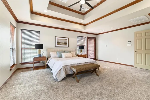 a spacious bedroom with a bed a dresser and a window