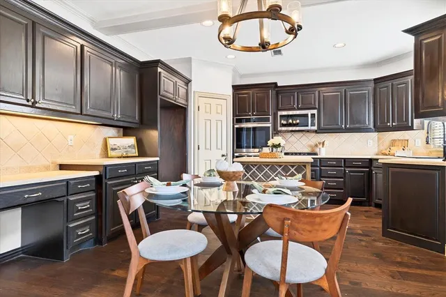 a view of a dining room with furniture a kitchen and chandelier