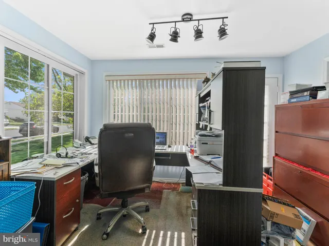 a view of a workspace with furniture and a window