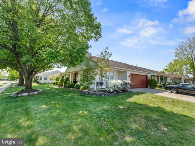 a view of a house with a big yard and large trees