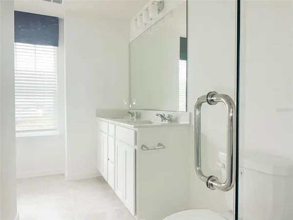 a bathroom with a granite countertop shower a mirror and a sink