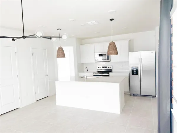 a kitchen with kitchen island a counter top space stainless steel appliances and cabinets