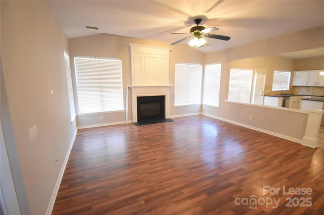 a view of an empty room with a fireplace and a window