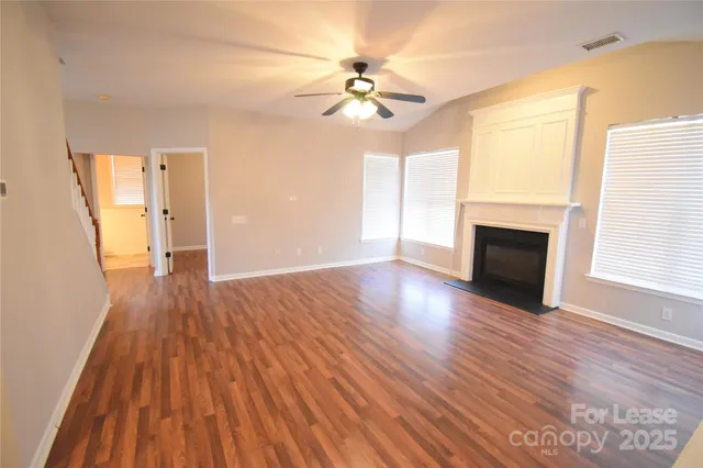 a view of a livingroom with wooden floor and a ceiling fan