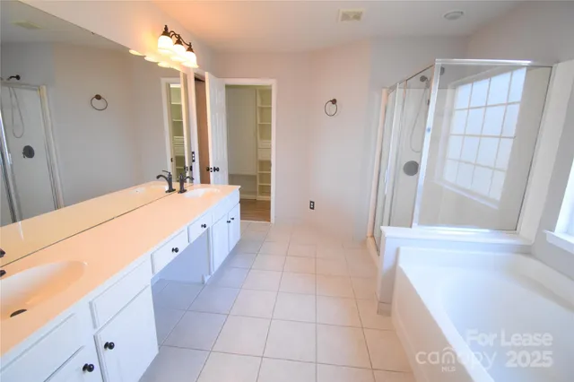 a spacious bathroom with a tub sink and shower